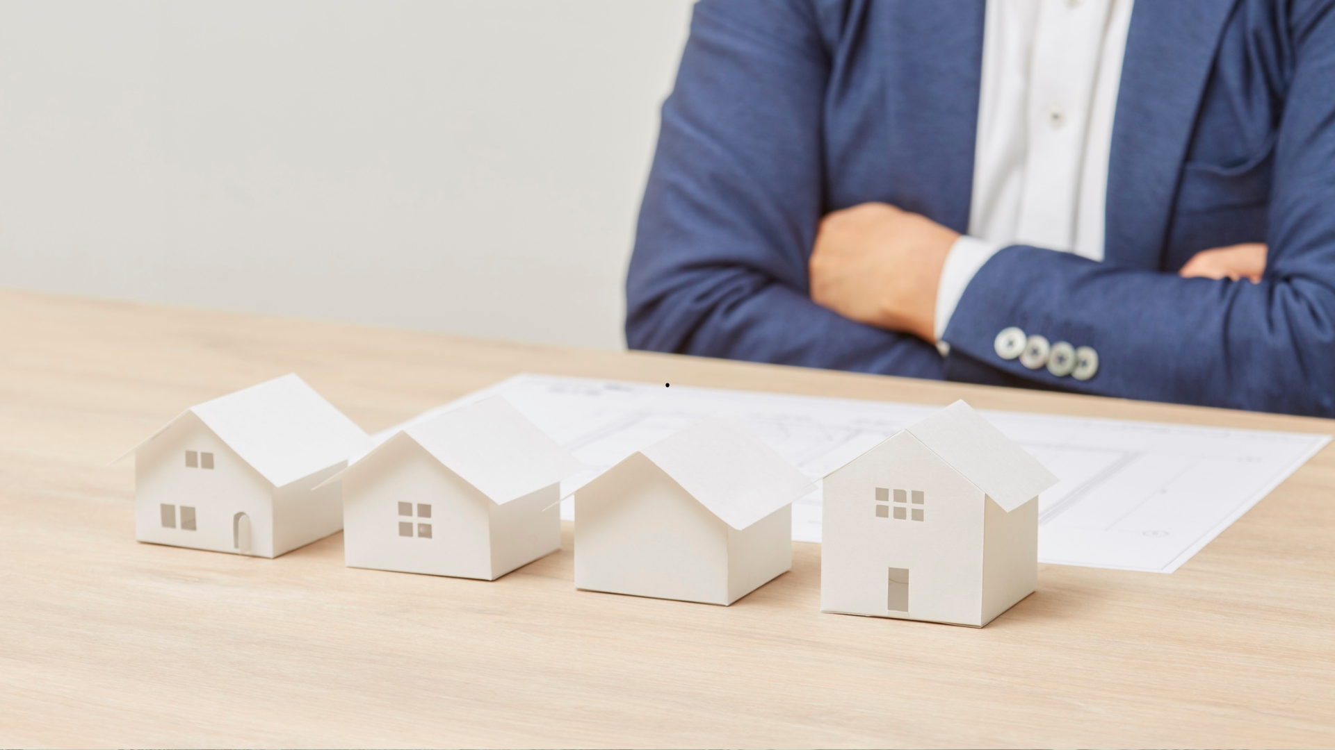 Modelos de casas sobre una mesa de asesoría inmobiliaria